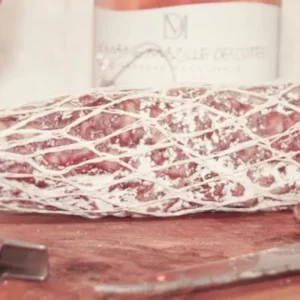 Photo d’une mini rosette 300g de la Salaison Montserret sur planche avec pain et verre de vin