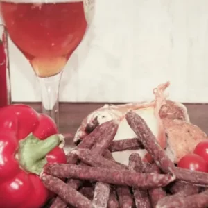 Sauciflettes mexicaines relevées au piment et poivron sur planche en bois