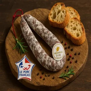 Saucisse artisanale d’Auvergne médaillée d’or, fabriquée par la Salaison du Velay, présentée sur une planche rustique avec pain de campagne