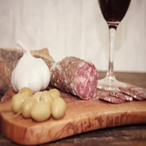 saucisson à l’ail tranché avec olives, pain et ail frais sur planche en bois
