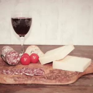 saucisson au comté Montserret avec fromage, pain et vin rouge sur planche en bois