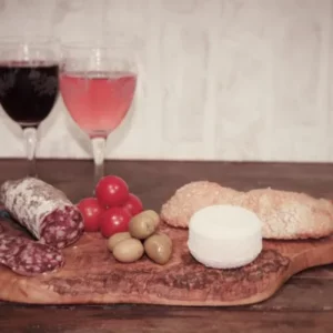 aucisson au fromage de chèvre de la Salaison Montserret accompagné de pain, fromage de chèvre et légumes sur planche