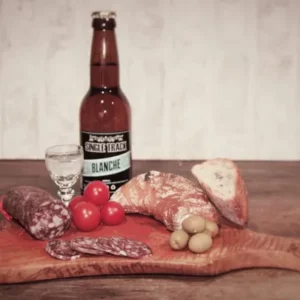 saucisson au génépi de la Salaison Montserret accompagné de bière blanche, pain, olives et tomates sur planche