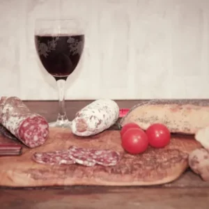 saucisson au kangourou de la Salaison Montserret accompagné de pain, vin rouge et tomates