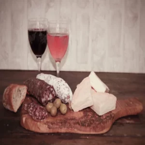 Saucisson au Munster avec pain, fromage, olives et vin sur planche en bois
