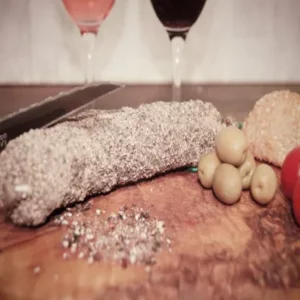 saucisson au poivre tranché avec olives et pain sur planche de bois