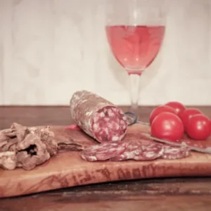 saucisson aux cèpes de la Salaison Montserret sur planche avec pain, cèpes et tomates cerises