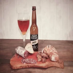 saucisson aux châtaignes tranché sur planche avec bière ambrée, pain, et châtaignes – salaison Monsterret