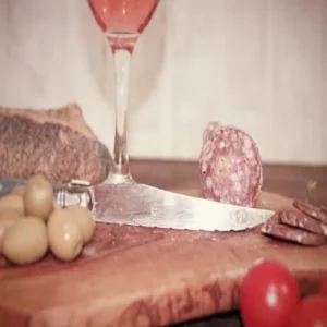 saucisson sec aux olives sur planche en bois avec pain et tomates