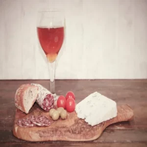 saucisson au bleu d’Auvergne tranché, fromage, tomates, olives et verre de bière sur planche en bois