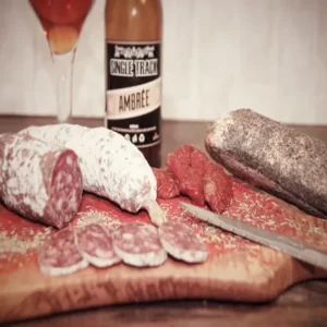 Saucisson provençal aux herbes de Provence et tomates séchées sur planche en bois